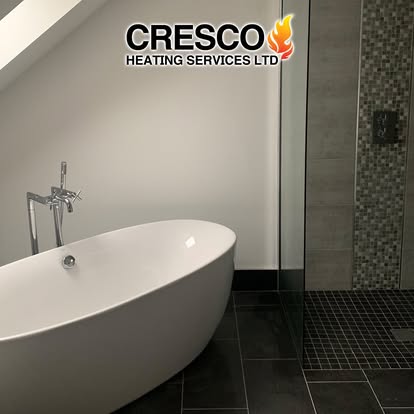Freestanding bath in a dark tiled bathroom